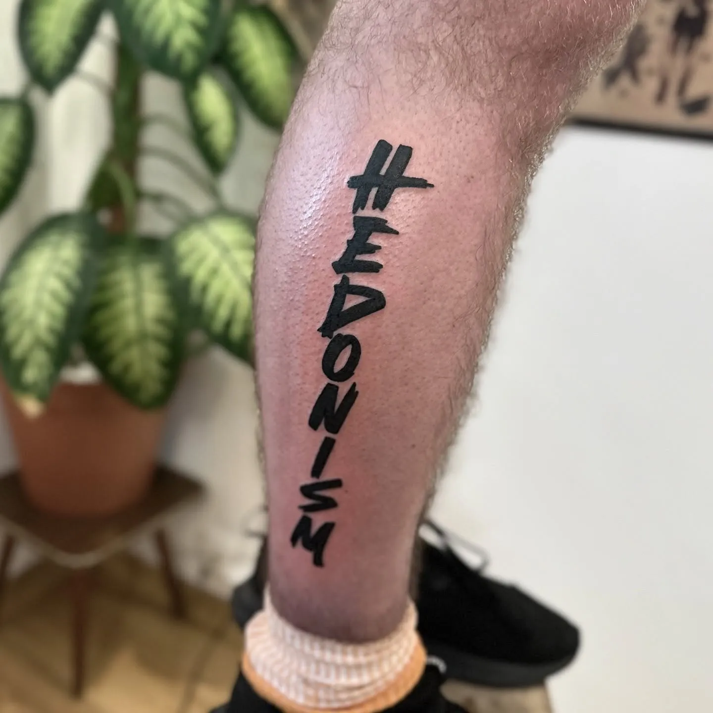 Lettering tatuaż z grubym konturem na łydce — tatuaż, Wujek Darek, Warszawa, Polska