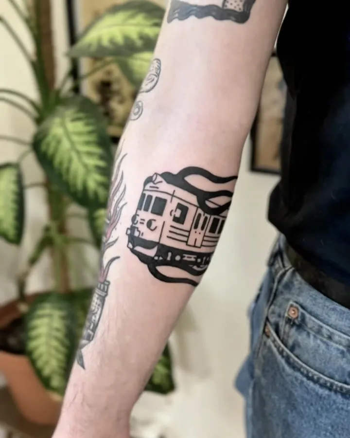Gruby kontur tatuaż pociągu metra z falującym dymem na przedramieniu — tatuaż, Wujek Darek, Warszawa, Polska