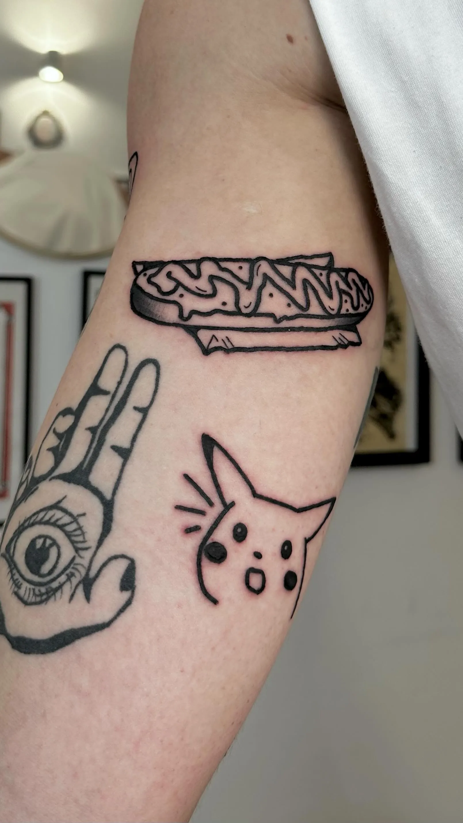 Ignorant tatuaż hot doga, kota i dłoni z okiem na przedramieniu — tatuaż, Wujek Darek, Warszawa, Polska