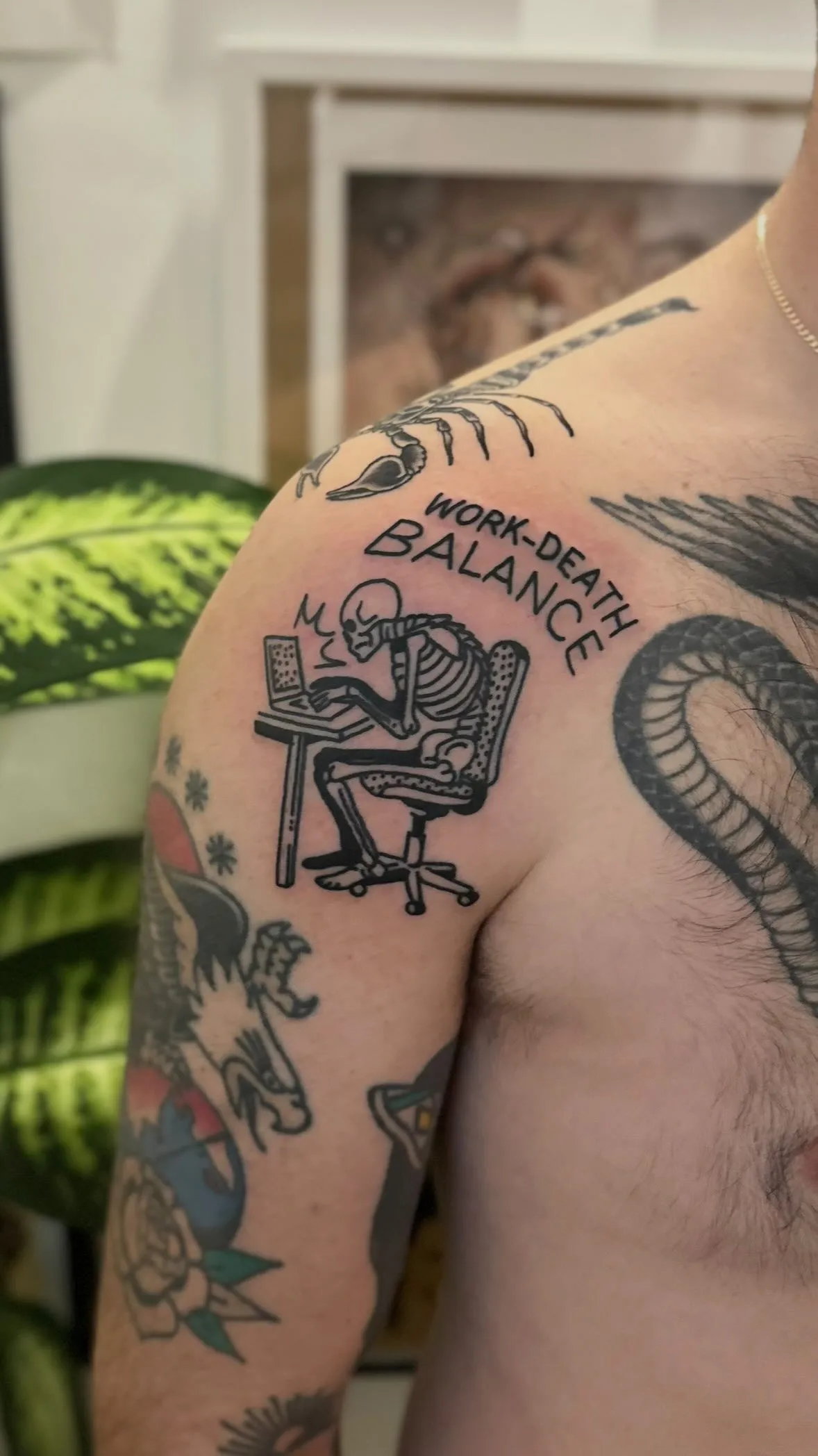 Ignorant tatuaż szkieletu przy laptopie z napisem w grubym konturze na ramieniu — tatuaż, Wujek Darek, Warszawa, Polska