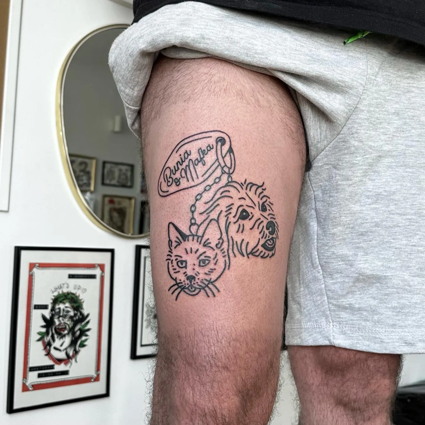 Tatuaż kota i psa z napisem w stylu ignorant na udzie — tatuaż, Wujek Darek, Warszawa, Polska