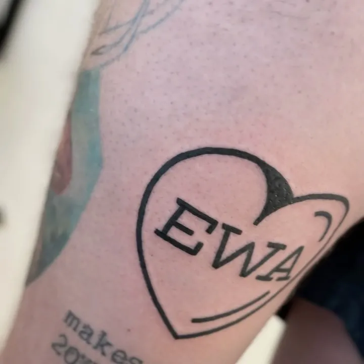 Tatuaż z napisem EWA w serduszku grubym konturem — tatuaż, Wujek Darek, Warszawa, Polska