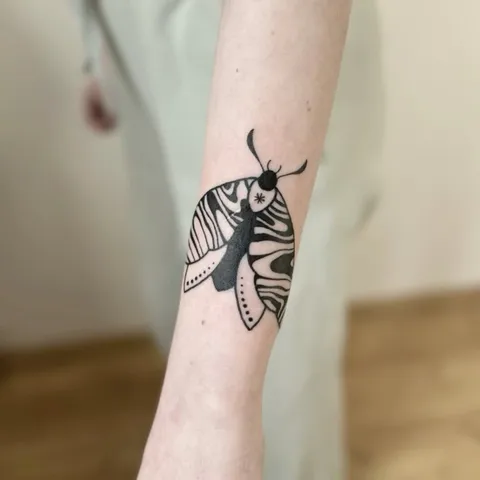 Tatuaż ćmy z grubym konturem na przedramieniu — Tattoo, Wujek Darek Tattoo, Warszawa