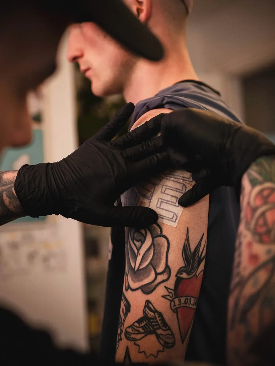 Tatuator z grubo obrysowanym sleeve'em przy niebieskiej szufladzie w studio (2) — Tattoo, Wujek Darek Tattoo, Warszawa
