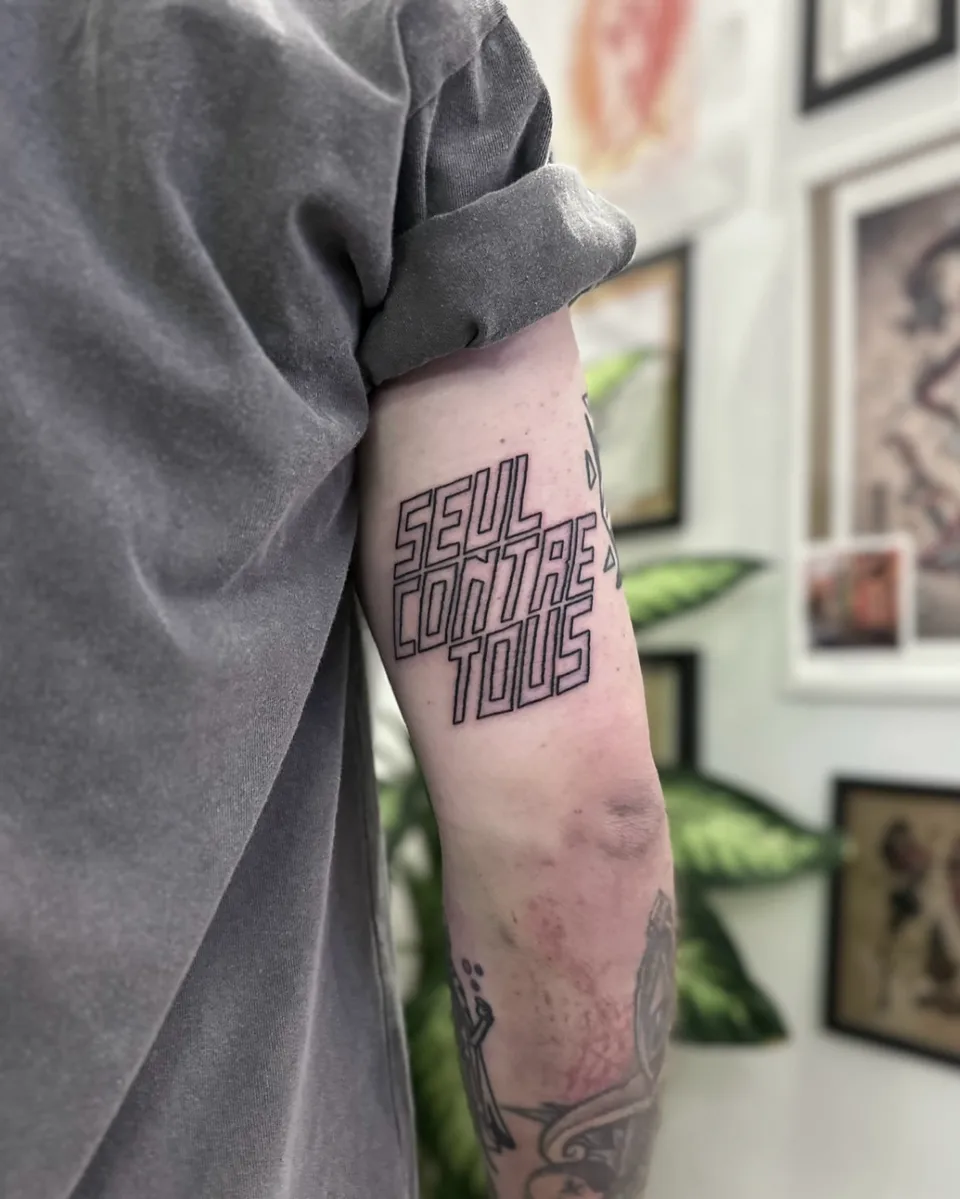 Ignorant tatuaż z trójliniowym liternictwem na zewnętrznej stronie ramienia (2) — Tattoo, Wujek Darek Tattoo, Warszawa