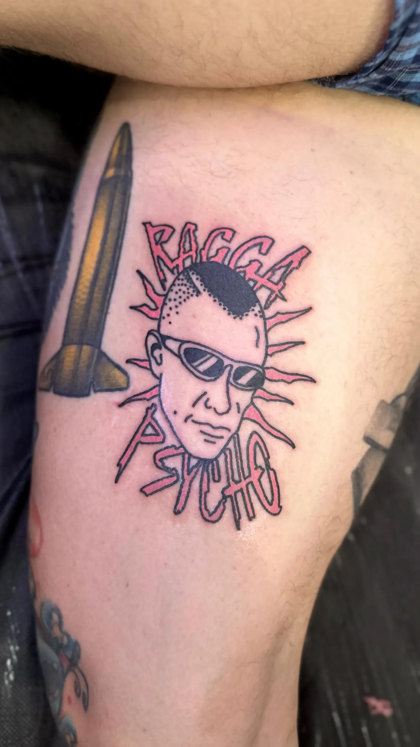 Ignorant tatuaż twarzy z okularami przeciwsłonecznymi i mohawkiem na udzie — Tattoo, Wujek Darek Tattoo, Warszawa