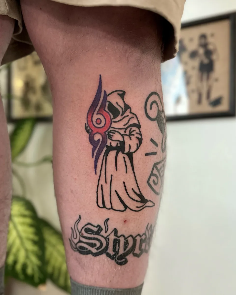 Ignorant tatuaż zakapturzonej postaci z symbolem na łydce — Tattoo, Wujek Darek Tattoo, Warszawa