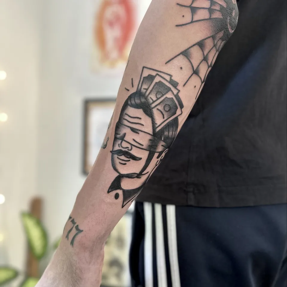 Ignorant tatuaż głowy mężczyzny z wąsem i banknotami na łokciu (2) — Tattoo, Wujek Darek Tattoo, Warszawa