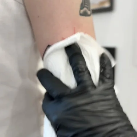 Tatuaż na nadgarstku wycierany gazą w rękawiczce — Tattoo, Wujek Darek Tattoo, Warszawa