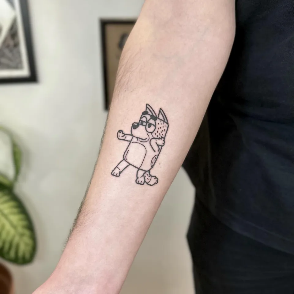 Ignorant tatuaż postaci psa z kreskówki na przedramieniu — Tattoo, Wujek Darek Tattoo, Warszawa