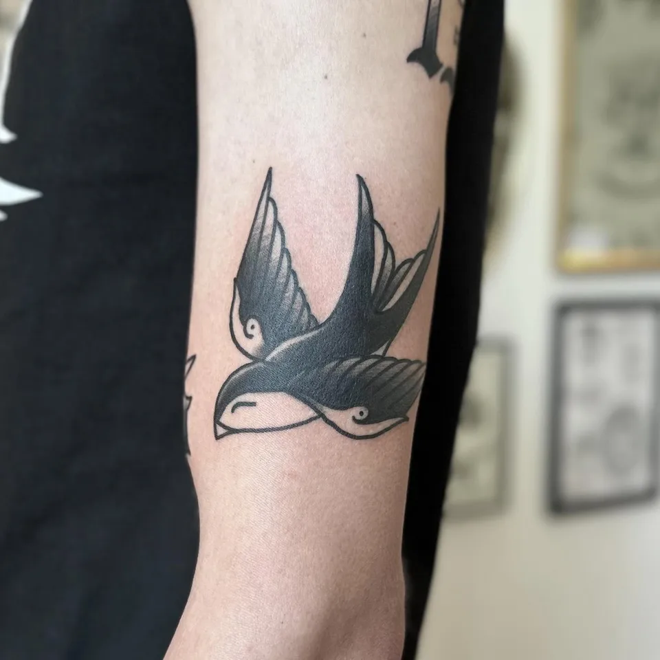 Tatuaż jaskółki w stylu gruby kontur na ramieniu (2) — Tattoo, Wujek Darek Tattoo, Warszawa