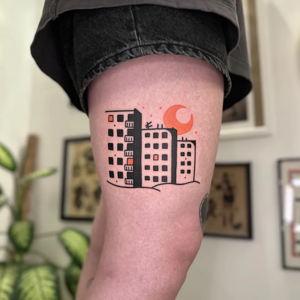 Ignorant tatuaż bloku mieszkalnego z czerwonym półksiężycem na udzie — Tattoo, Wujek Darek Tattoo, Warszawa