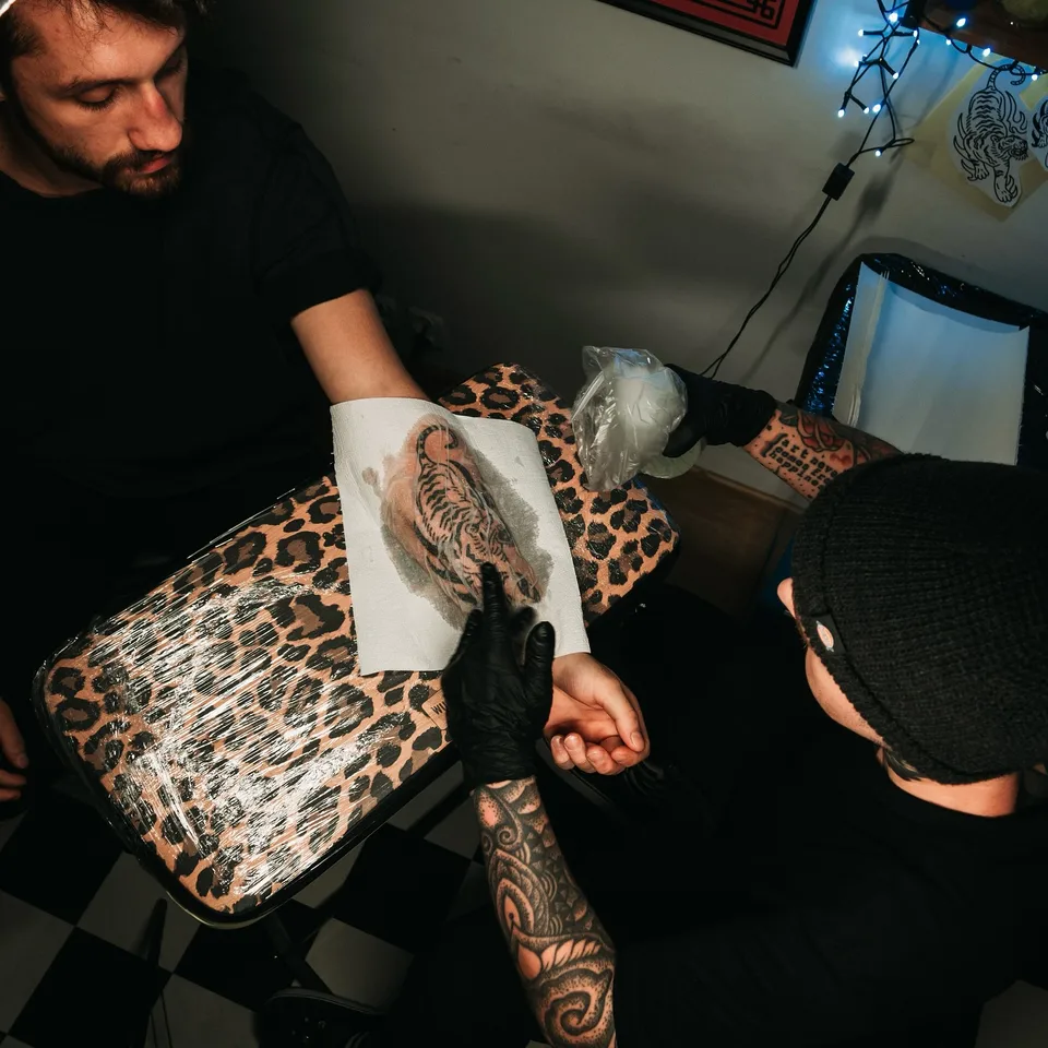 Tatuażysta podczas pracy z miedzianą maszyną rotacyjną (2) — Tattoo, Wujek Darek Tattoo, Warszawa