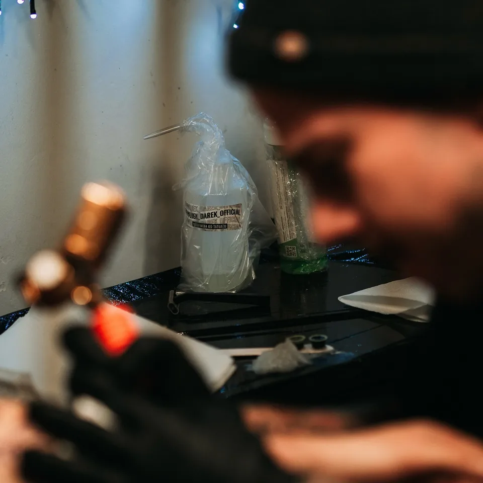 Tatuażysta podczas pracy z miedzianą maszyną rotacyjną (3) — Tattoo, Wujek Darek Tattoo, Warszawa