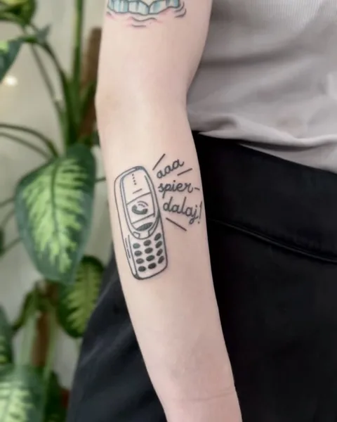 Ignorant tatuaż starej nokii na przedramieniu z dymkiem komiksowym — Tattoo, Wujek Darek Tattoo, Warszawa