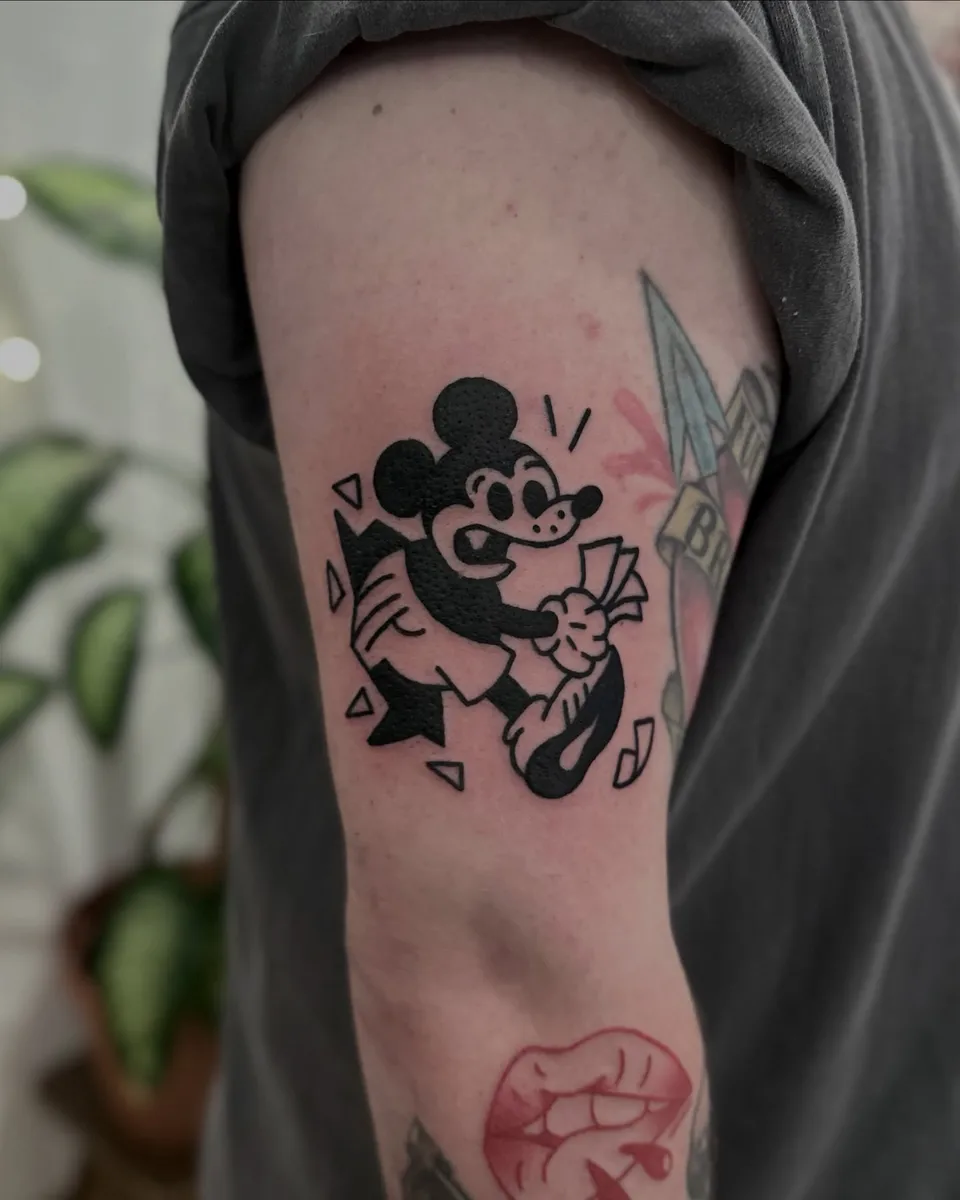 Ignorant tatuaż Myszki Miki z banknotami na ramieniu — Tattoo, Wujek Darek Tattoo, Warszawa
