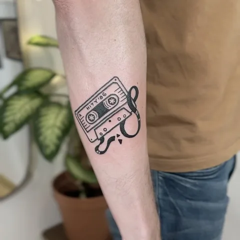 Tatuaż kasety magnetofonowej z wystającą taśmą na przedramieniu — Tattoo, Wujek Darek Tattoo, Warszawa