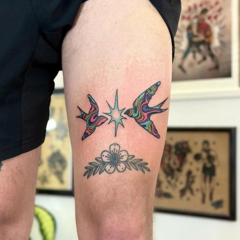 Kolorowe jaskółki z gwiazdą i kwiatem w stylu ignorant na udzie — Tattoo, Wujek Darek Tattoo, Warszawa
