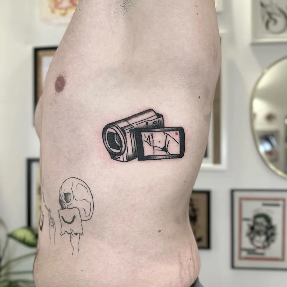 Tatuaż kamery wideo z motywem ignorant na żebrach — Tattoo, Wujek Darek Tattoo, Warszawa
