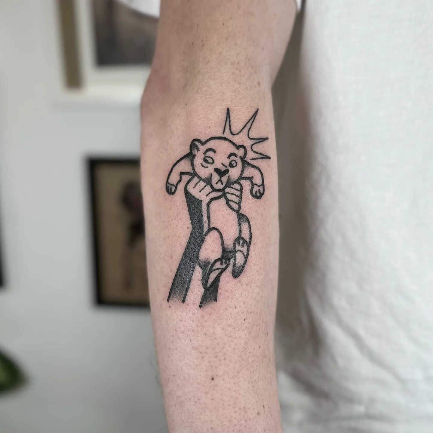 Ignorant tatuaż biegnącego niedźwiedzia z grubym konturem na przedramieniu — Tattoo, Wujek Darek Tattoo, Warszawa
