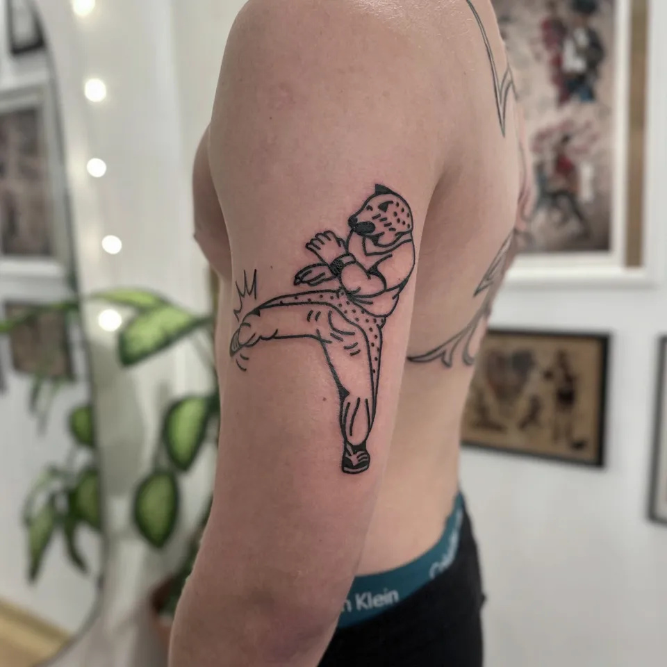 Ignorant tatuaż geparda w stylu karate na ramieniu — Tattoo, Wujek Darek Tattoo, Warszawa
