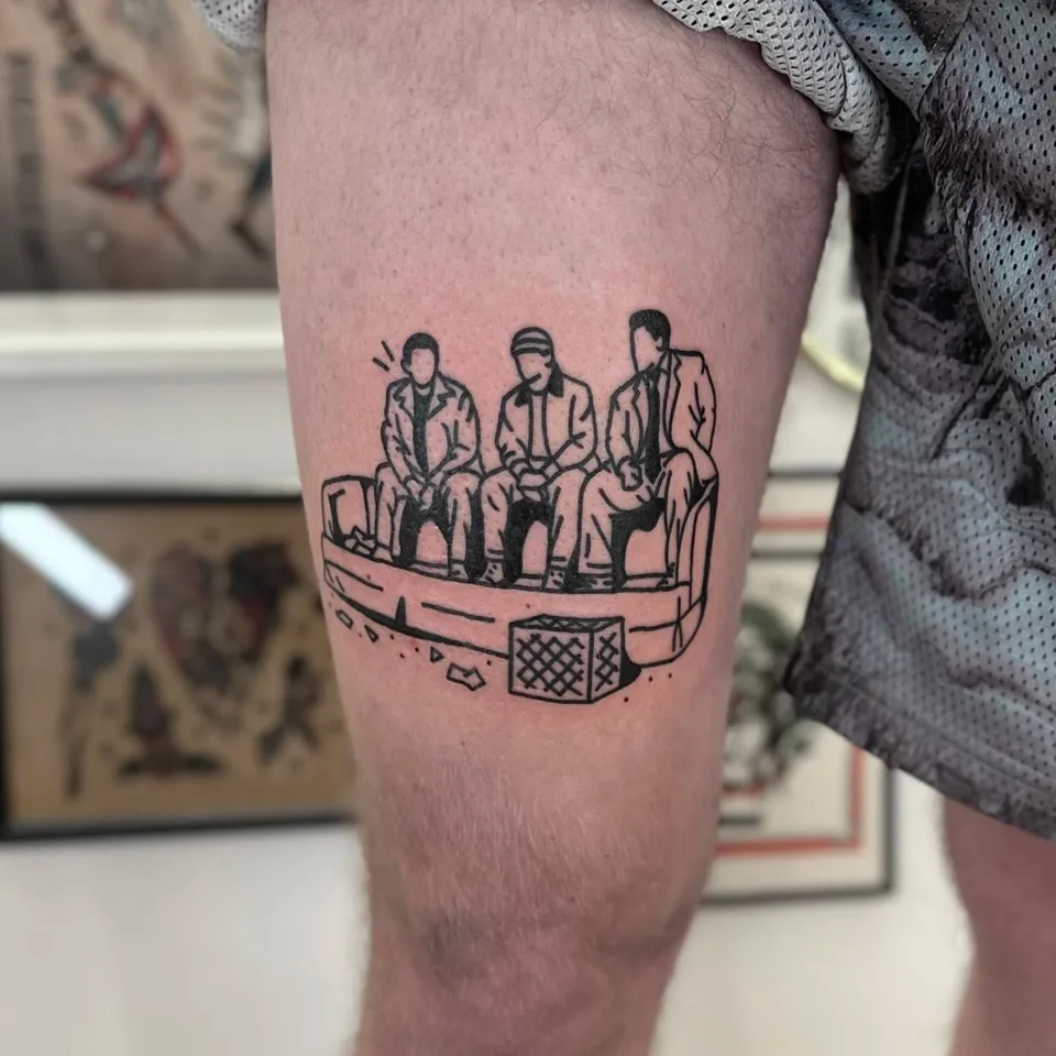 Ignorant tatuaż trzech postaci na kanapie na udzie — Tattoo, Wujek Darek Tattoo, Warszawa