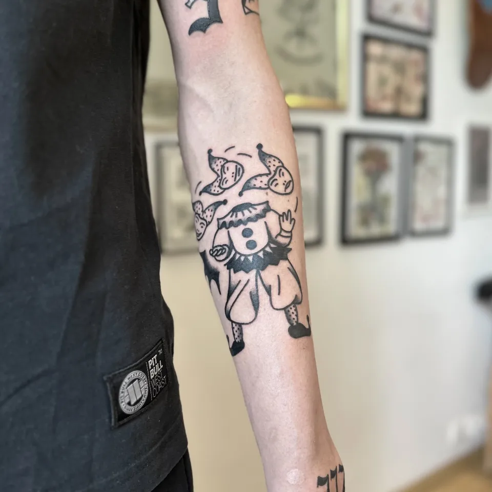 Ignorant tatuaż klauna żonglującego głowami na przedramieniu — Tattoo, Wujek Darek Tattoo, Warszawa