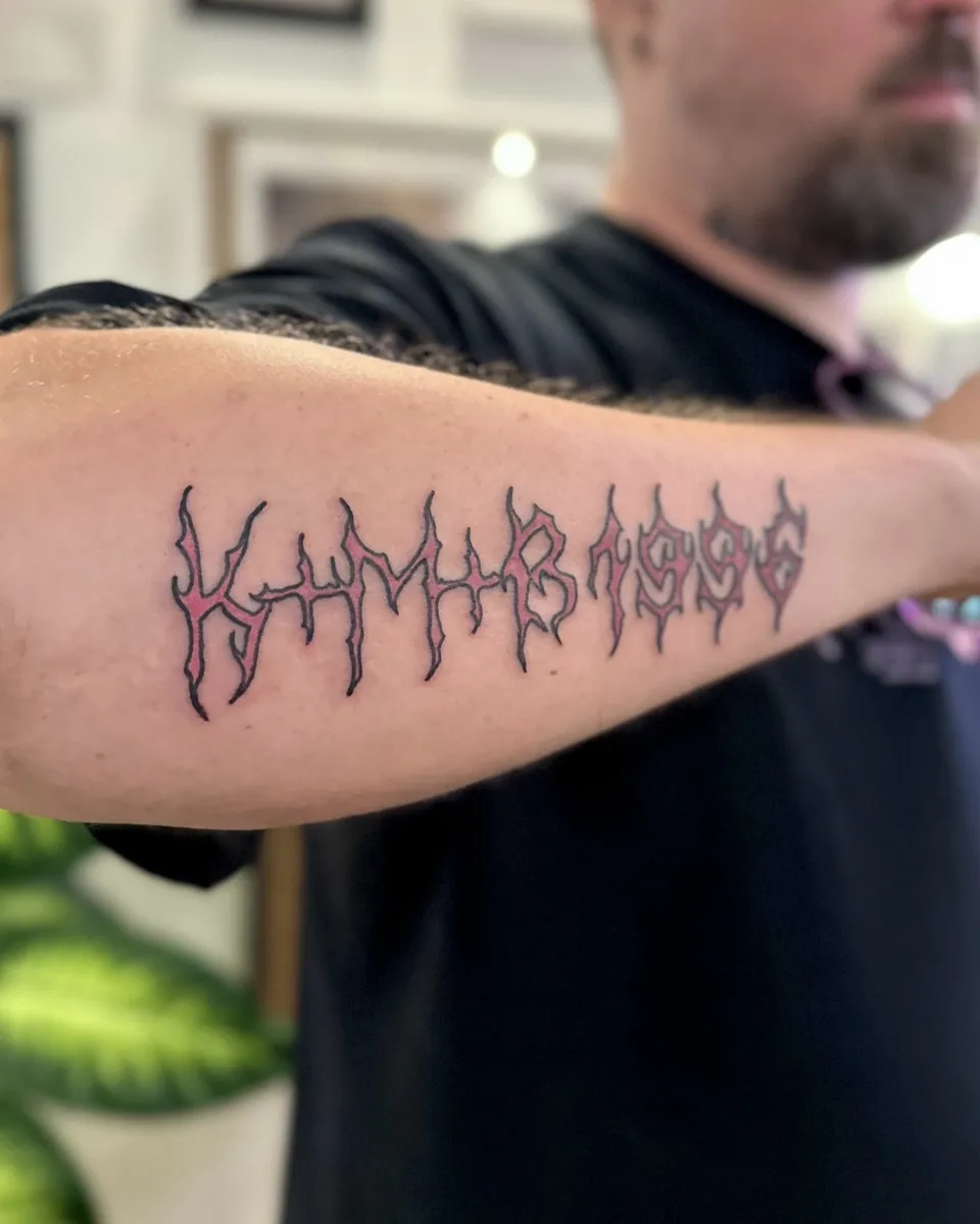Gruby kontur napis na przedramieniu w stylu death metalowym — Tattoo, Wujek Darek Tattoo, Warszawa