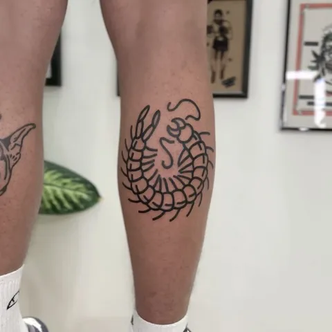 Tatuaż stonogi zwiniętej w okrąg na łydce – gruby kontur — Tattoo, Wujek Darek Tattoo, Warszawa