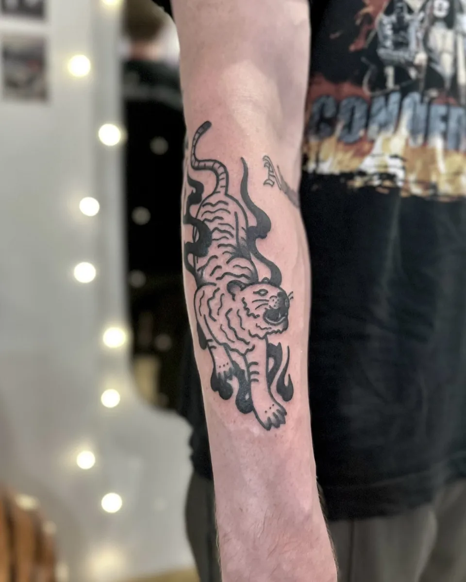 Tatuaż tygrysa z grubym konturem na przedramieniu — Tattoo, Wujek Darek Tattoo, Warszawa