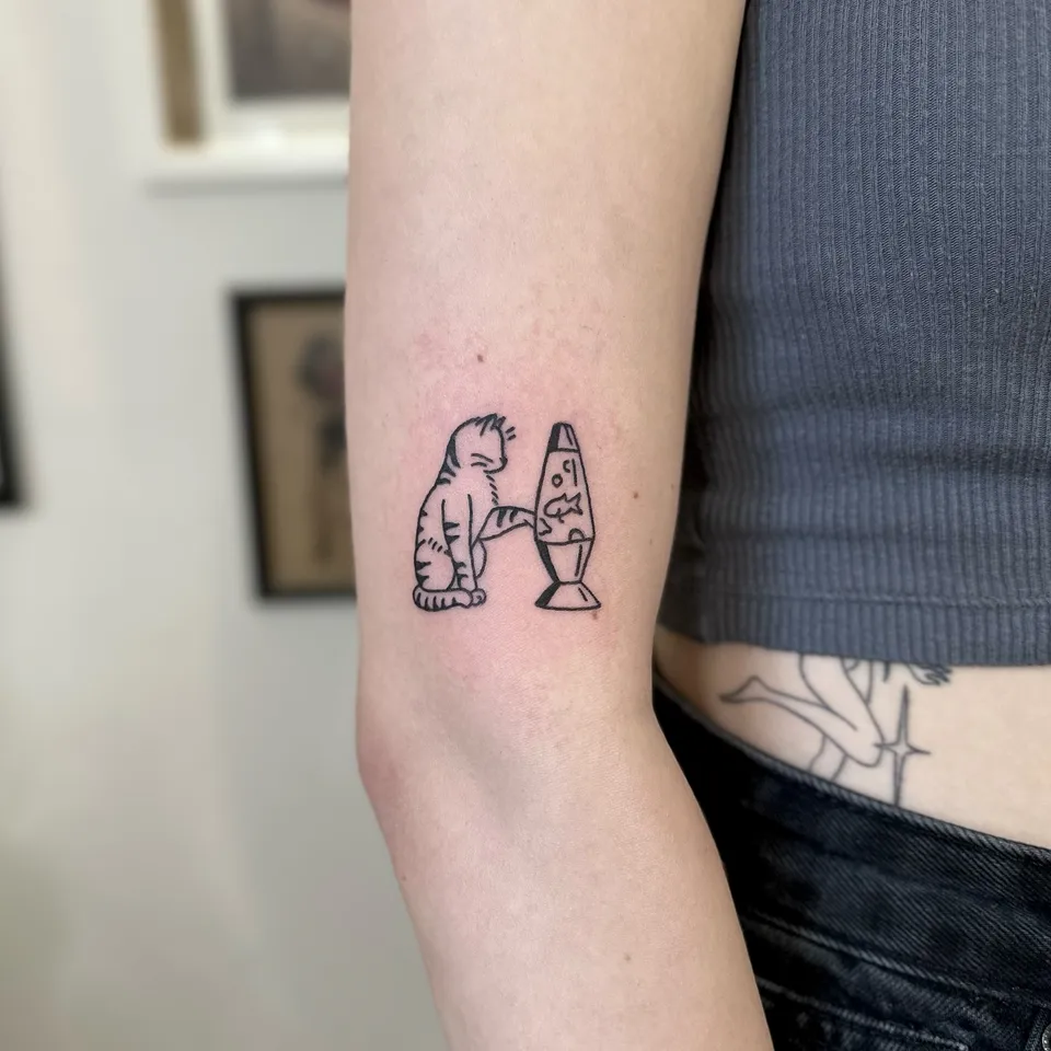 Ignorant tatuaż kota wpatrzonego w lampę lawową z rybką — Tattoo, Wujek Darek Tattoo, Warszawa