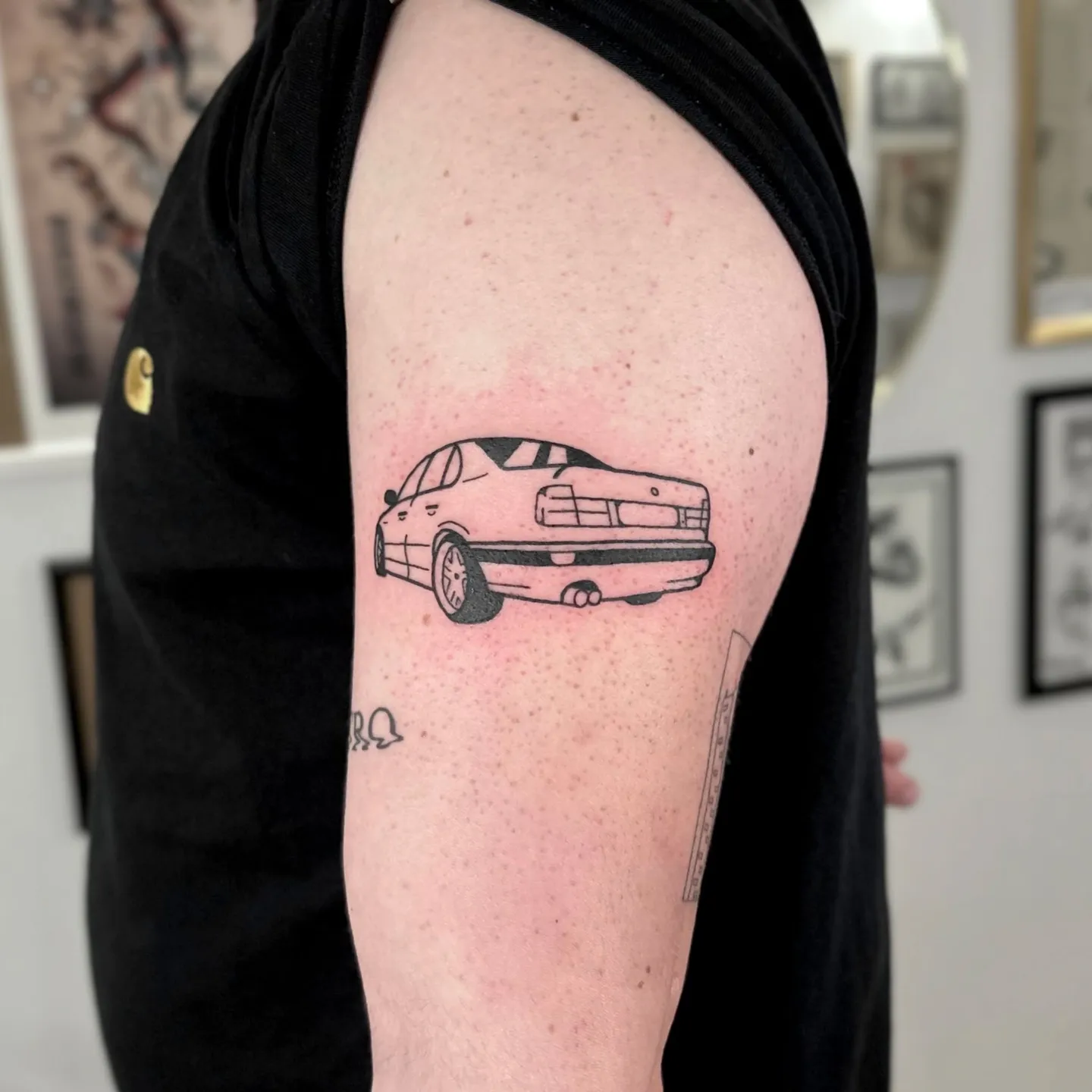 Tatuaż samochodu osobowego na ramieniu w stylu grubego konturu — Tattoo, Wujek Darek Tattoo, Warszawa