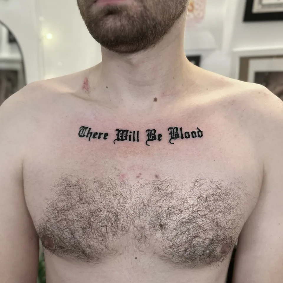 Tatuaż z napisem w stylu gotyckim na klatce piersiowej — Tattoo, Wujek Darek Tattoo, Warszawa