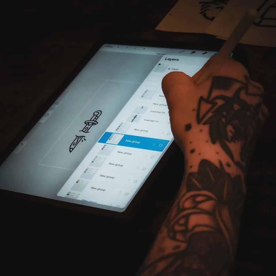Tatuator z tatuażami na twarzy i szyi podczas pracy maszyną rotacyjną (2) — Tattoo, Wujek Darek Tattoo, Warszawa