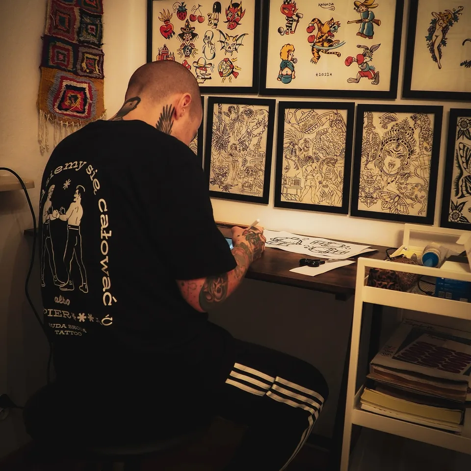 Tatuator z tatuażami na twarzy i szyi podczas pracy maszyną rotacyjną (3) — Tattoo, Wujek Darek Tattoo, Warszawa