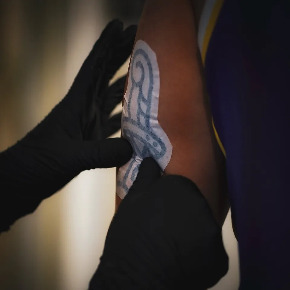 Tatuator z tatuażami na twarzy i szyi podczas pracy maszyną rotacyjną (4) — Tattoo, Wujek Darek Tattoo, Warszawa