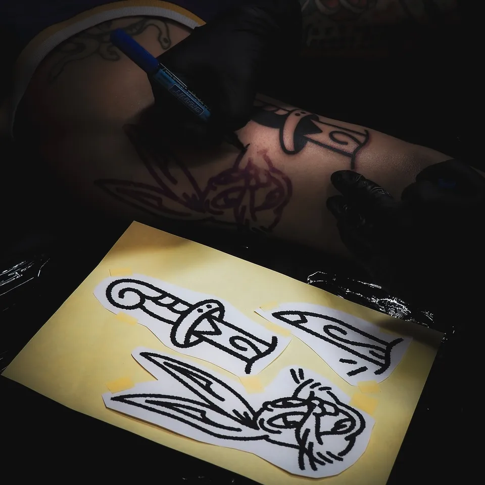 Tatuator z tatuażami na twarzy i szyi podczas pracy maszyną rotacyjną (6) — Tattoo, Wujek Darek Tattoo, Warszawa