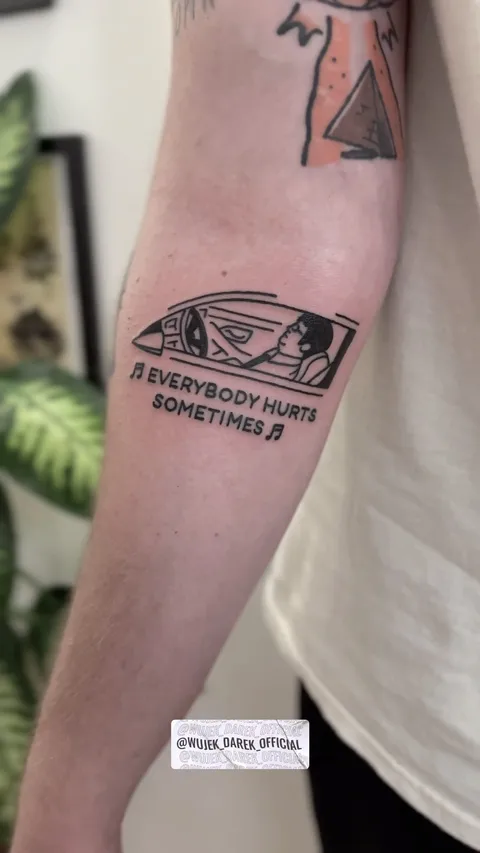 Ignorant tatuaż z postacią w samochodzie i napisem na przedramieniu — Tattoo, Wujek Darek Tattoo, Warszawa