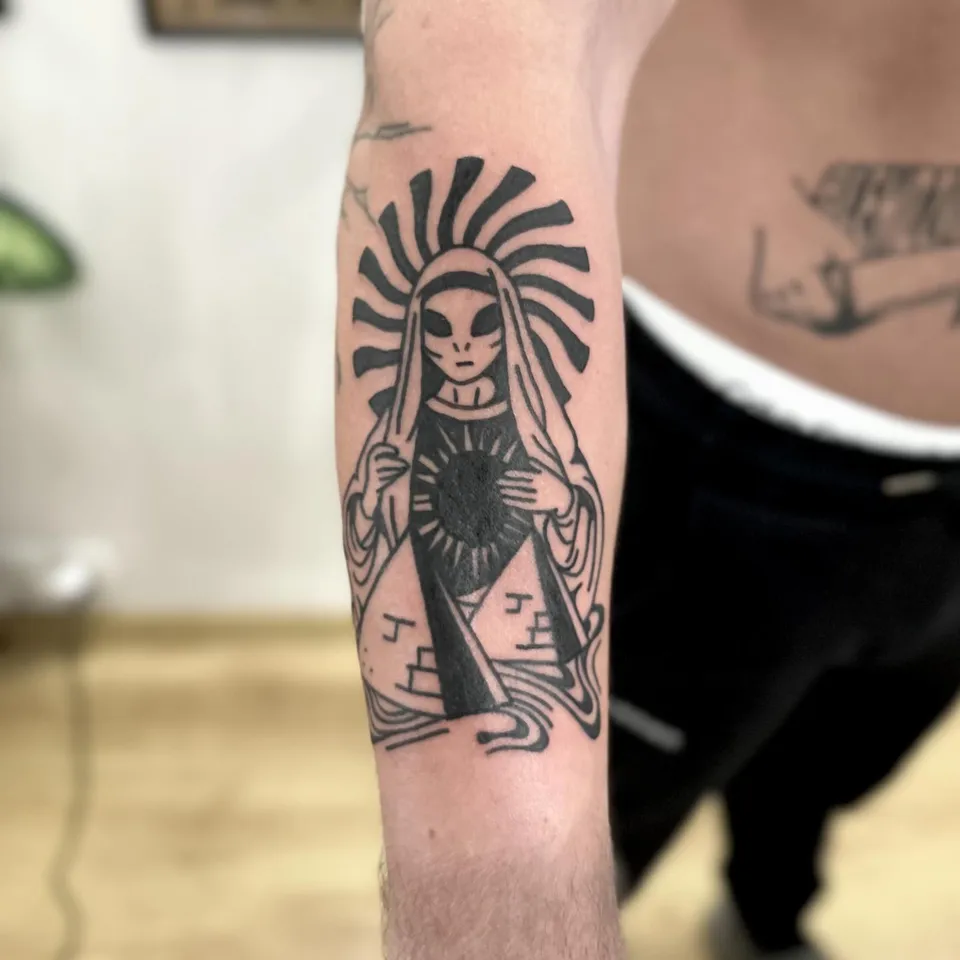 Ignorant tatuaż kosmity w stylu Matki Boskiej z piramidą na przedramieniu (2) — Tattoo, Wujek Darek Tattoo, Warszawa