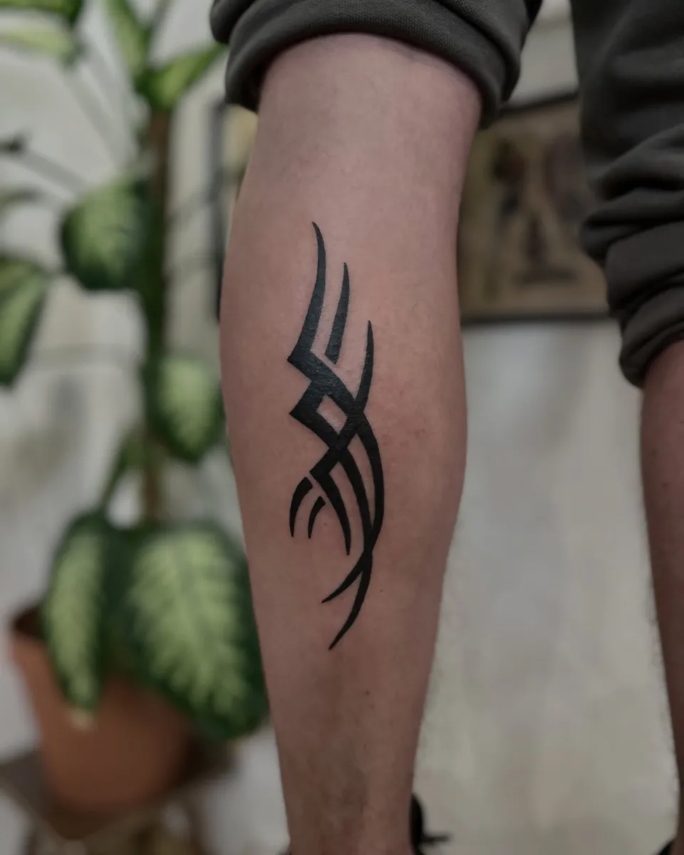 Tribal tatuaż na łydce z grubym konturem i ostrymi szpikulcami — Tattoo, Wujek Darek Tattoo, Warszawa