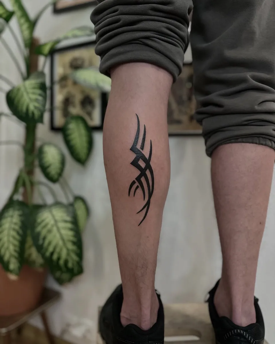 Tribal tatuaż na łydce z grubym konturem i ostrymi szpikulcami (2) — Tattoo, Wujek Darek Tattoo, Warszawa