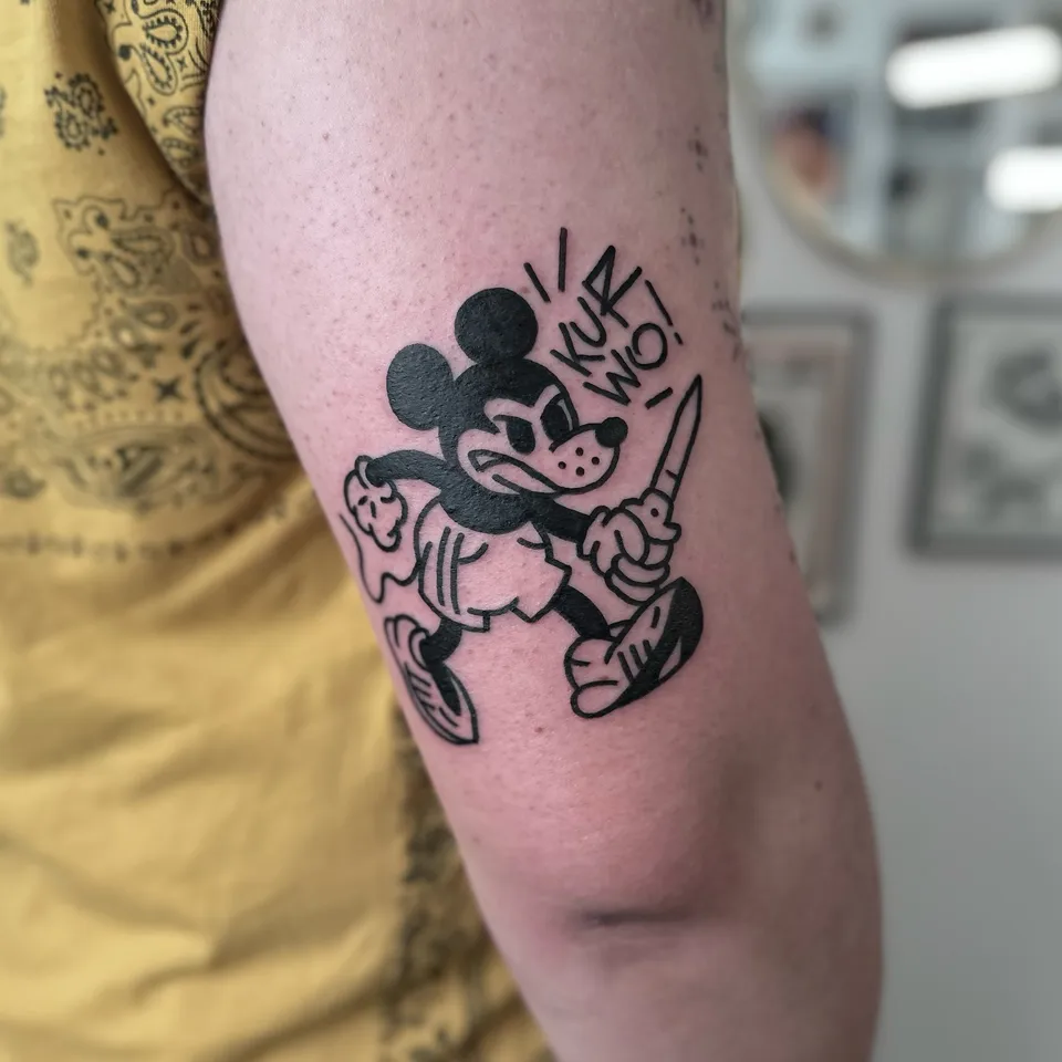 Ignorant tatuaż myszy z nożem na ramieniu w grubym konturze — Tattoo, Wujek Darek Tattoo, Warszawa