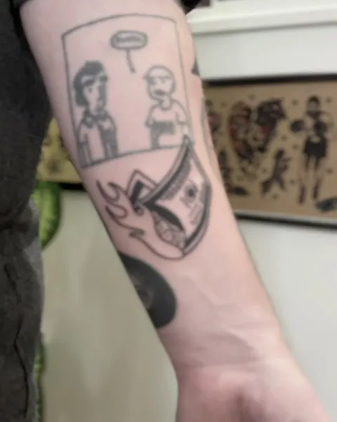 Ignorant tatuaż komiksowy z postaciami i rolką banknotów w płomieniach na przedramieniu — Tattoo, Wujek Darek Tattoo, Warszawa