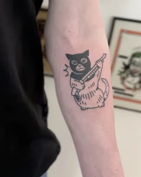 Ignorant tatuaż kota w masce z karabinem na przedramieniu — Tattoo, Wujek Darek Tattoo, Warszawa