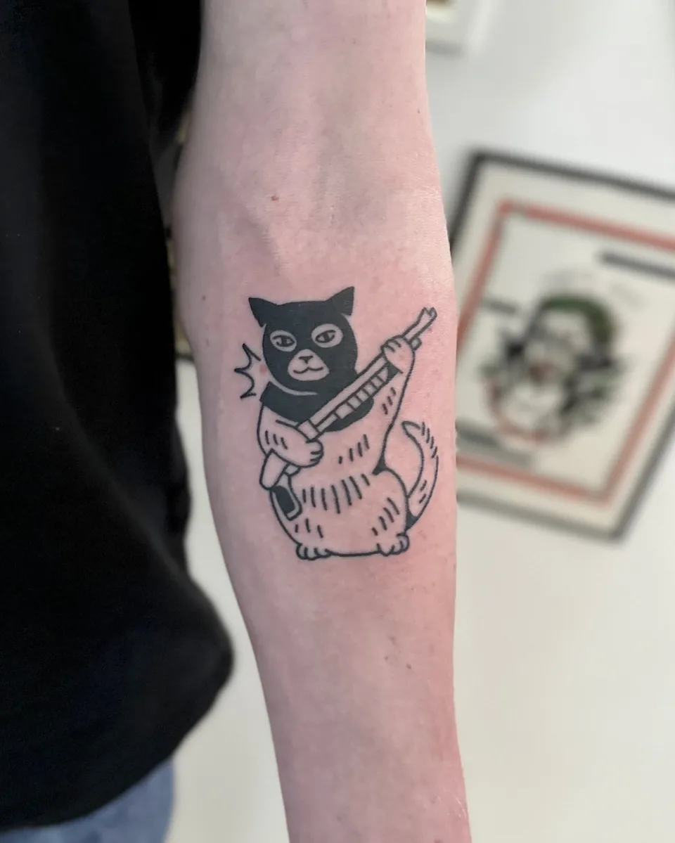 Ignorant tatuaż kota w masce z karabinem na przedramieniu (2) — Tattoo, Wujek Darek Tattoo, Warszawa