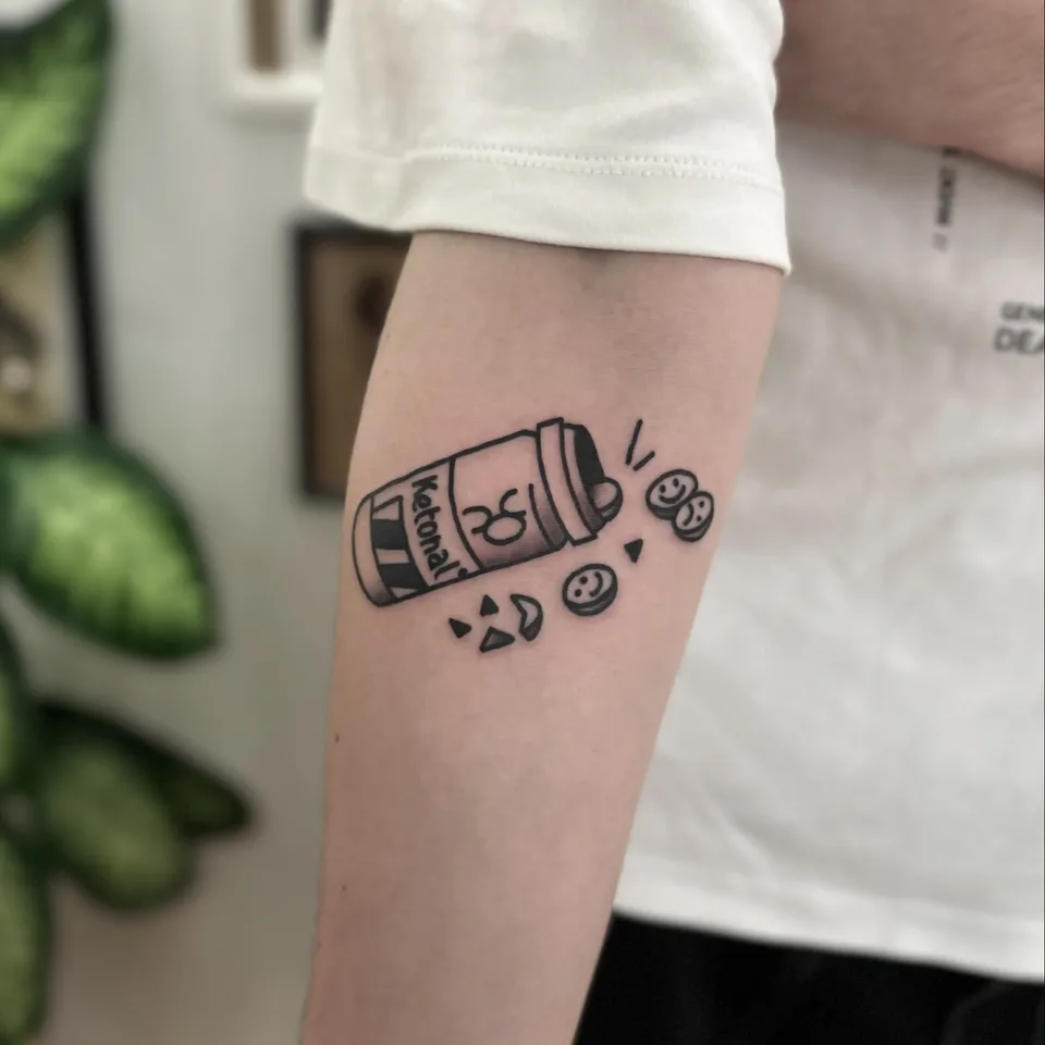 Ignorant tatuaż przewróconego słoiczka z tabletkami na przedramieniu — Tattoo, Wujek Darek Tattoo, Warszawa