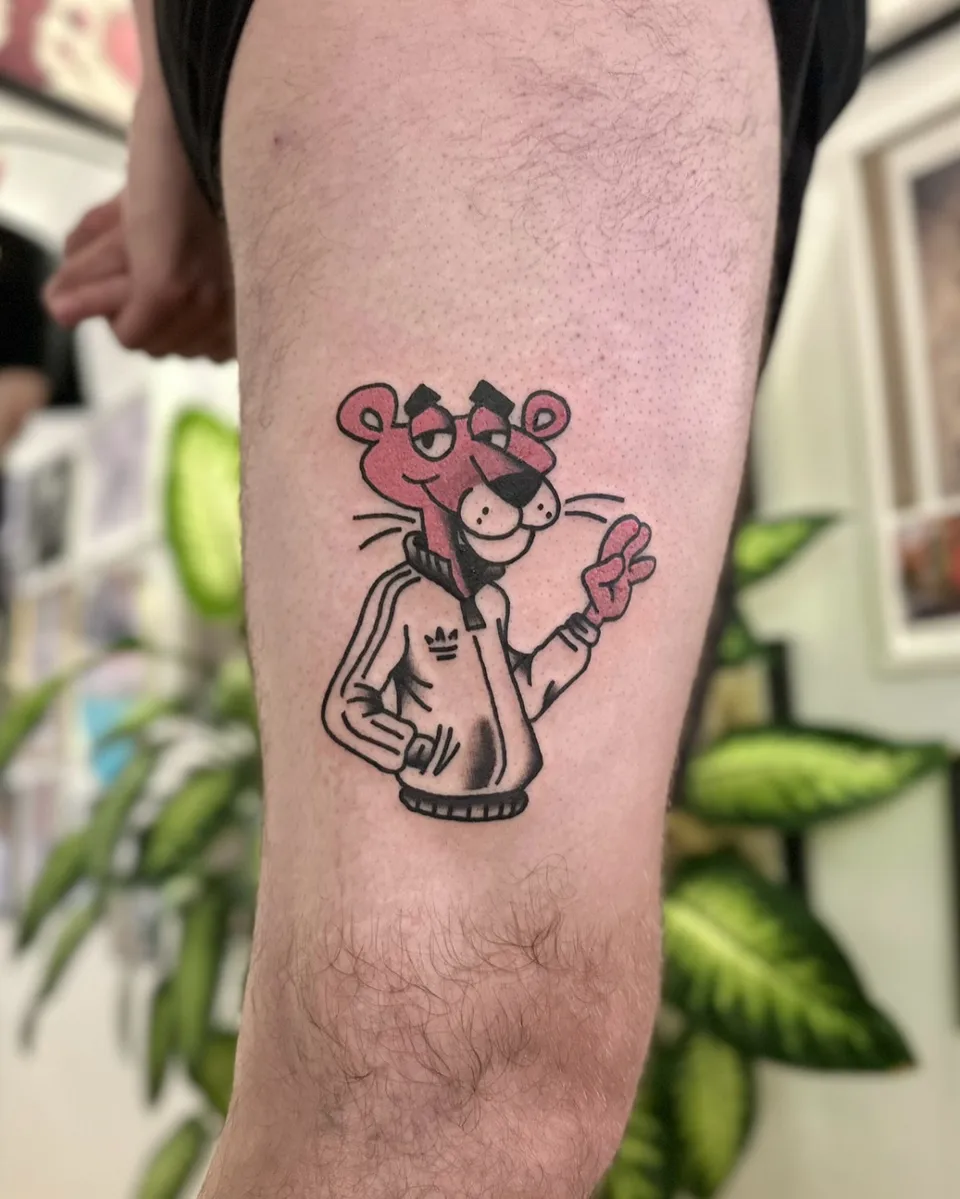 Tatuaż Różowej Pantery w dresie z grubym konturem na udzie — Tattoo, Wujek Darek Tattoo, Warszawa