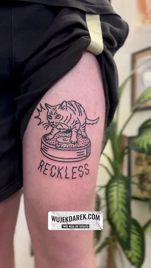 Ignorant tatuaż kota na gramofonie na udzie z napisem — Tattoo, Wujek Darek Tattoo, Warszawa