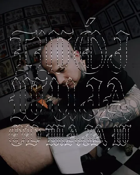 Tatuażysta przy pracy w studiu z galerią wzorów na ścianie — Tattoo, Wujek Darek Tattoo, Warszawa