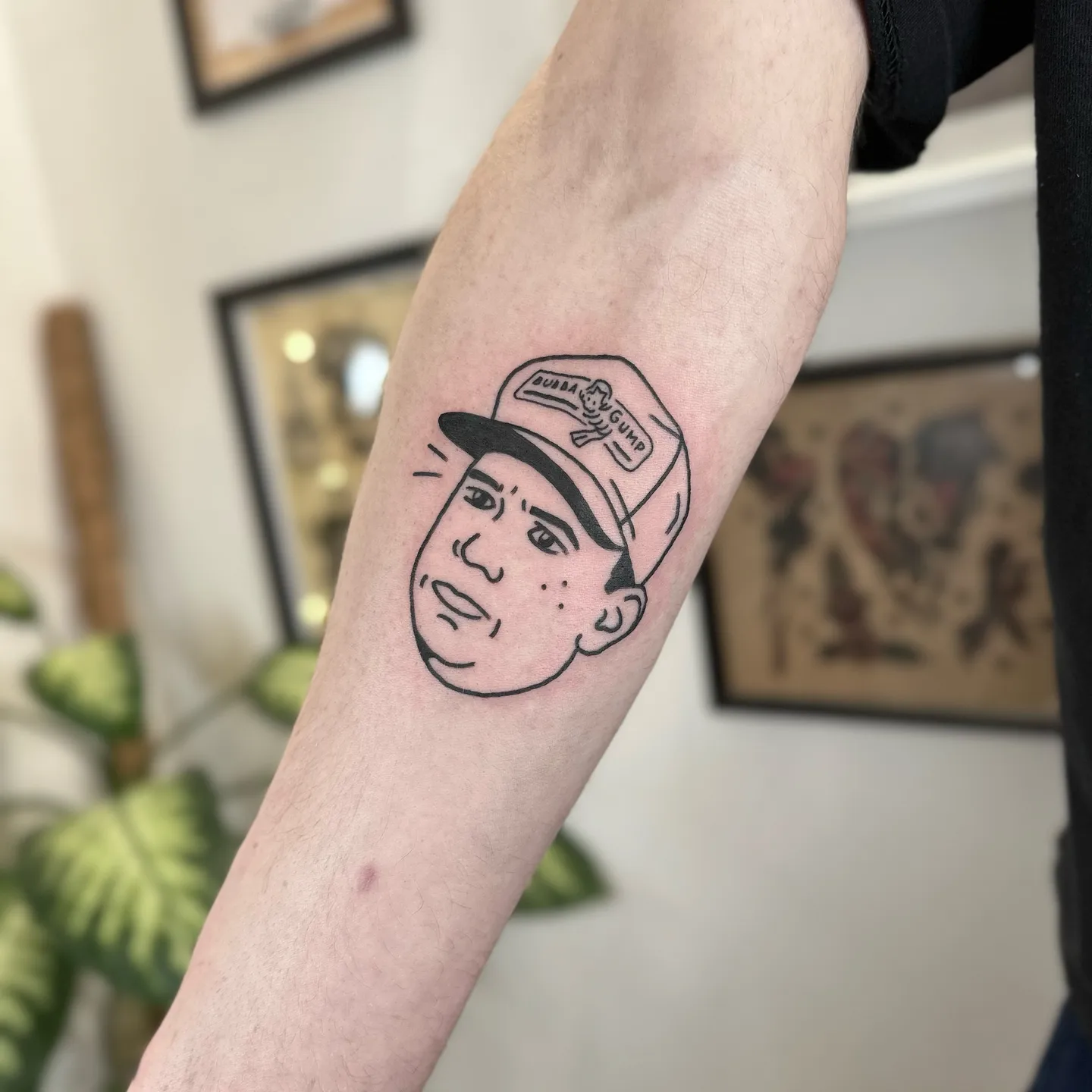 Ignorant tatuaż twarzy w czapce z daszkiem na przedramieniu — Tattoo, Wujek Darek Tattoo, Warszawa